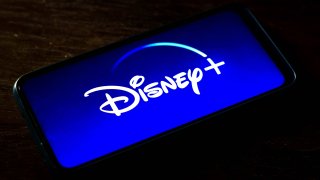 In this photo illustration the Disney+ logo seen displayed on a smartphone screen.
