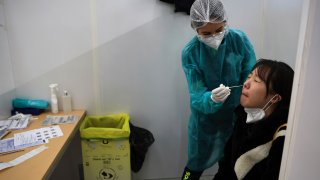 A passenger arriving from China is tested for COVID-19 at the Roissy Charles de Gaulle airport, north of Paris, Sunday, Jan. 1, 2023.