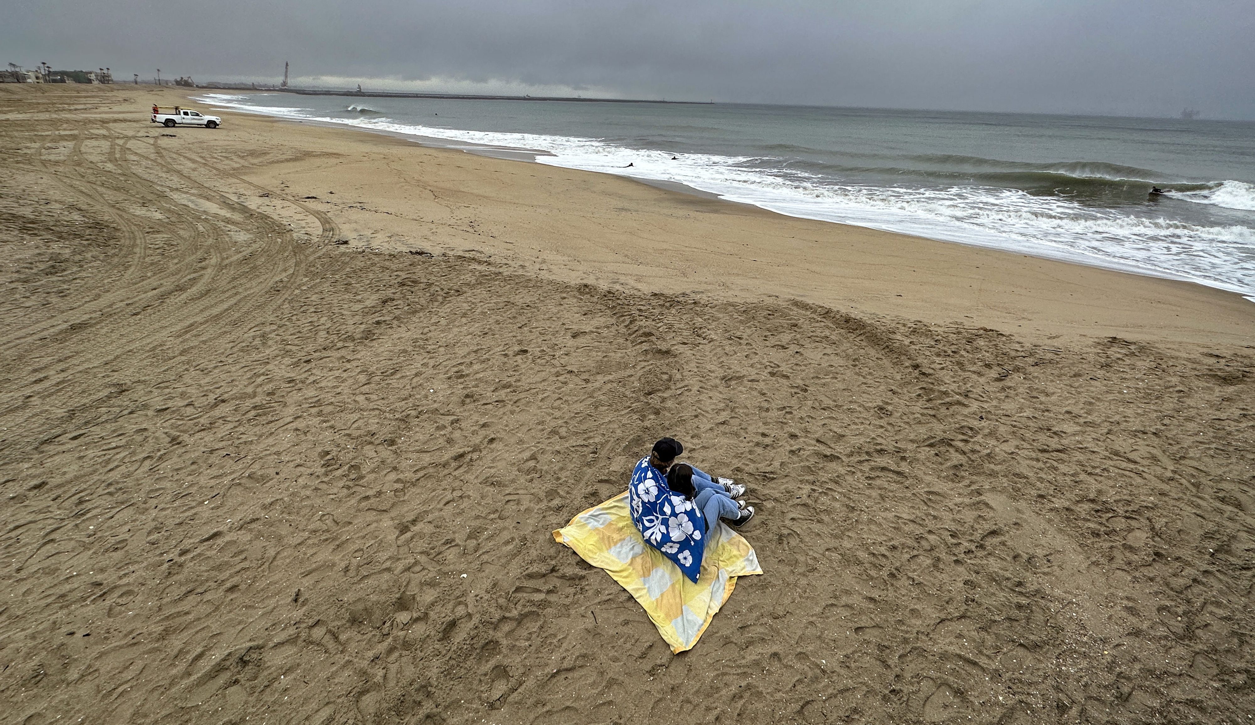 Seal Beach, CA – January 03: Beachgoers watch surfers south of the Seal Beach Pier during the rain in Seal Beach, CA, on Tuesday, January 3, 2023. (Photo by Jeff Gritchen/MediaNews Group/Orange County Register via Getty Images)