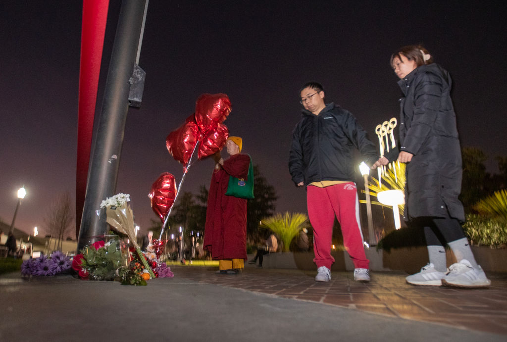 A person pays their respects at a memorial for Monterey Park mass shooting victims after a news conference at the Monterey Park Civic Center