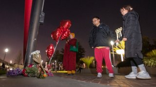 A person pays their respects at a memorial for Monterey Park mass shooting victims after a news conference at the Monterey Park Civic Center