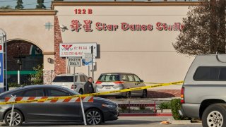 A Monterey Park police officer stands outside the Star Dance Studio.