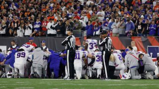 Buffalo Bills players take a knee following the collapse of teammate Damar Hamlin during the team’s game against the Cincinnati Bengals.