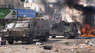 Smoke from fires fills the air as Palestinians clash with Israeli forces in the West Bank city of Nablus, Wednesday, Feb. 22, 2023.