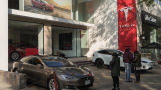 Costumers look at a Tesla Motors Inc. vehicles outside a store on the Avenida Presidente Masaryk in Mexico City, Mexico
