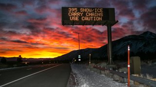 A freeway sign warns drivers of chain requirements.