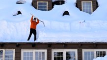 Stephen Calleros begins to clear up to 6 feet of snow off the roof of Dianes Saddleback Grill and Hotel in Lake Arrowhead.