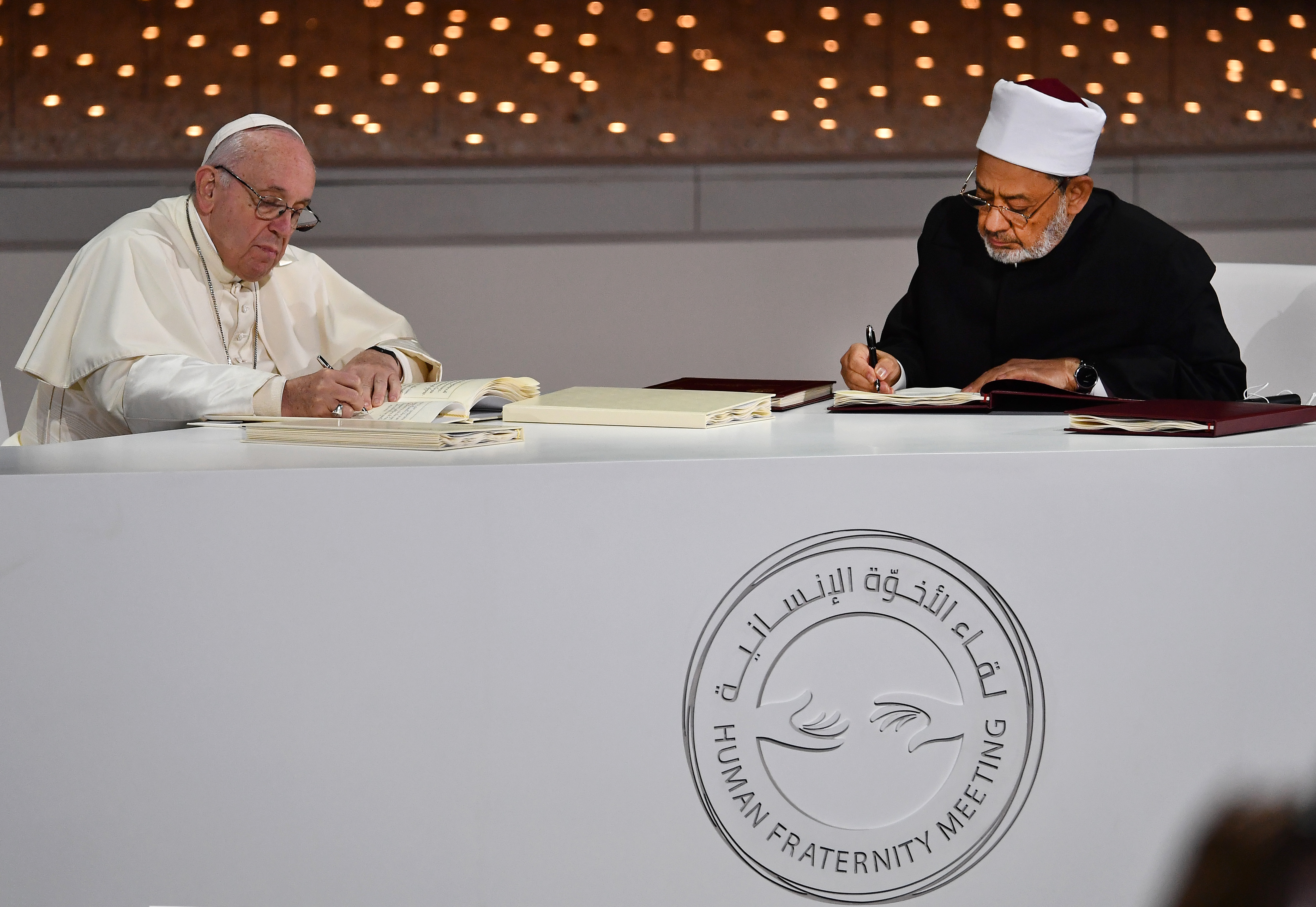 Pope Francis and Egypt’s Azhar Grand Imam Sheikh Ahmed al-Tayeb sign documents during the Human Fraternity Meeting at the Founders Memorial in Abu Dhabi on Feb. 4, 2019. Pope Francis rejected “hatred and violence” in the name of God, on the first visit by the head of the Catholic church to the Muslim-majority Arabian Peninsula.