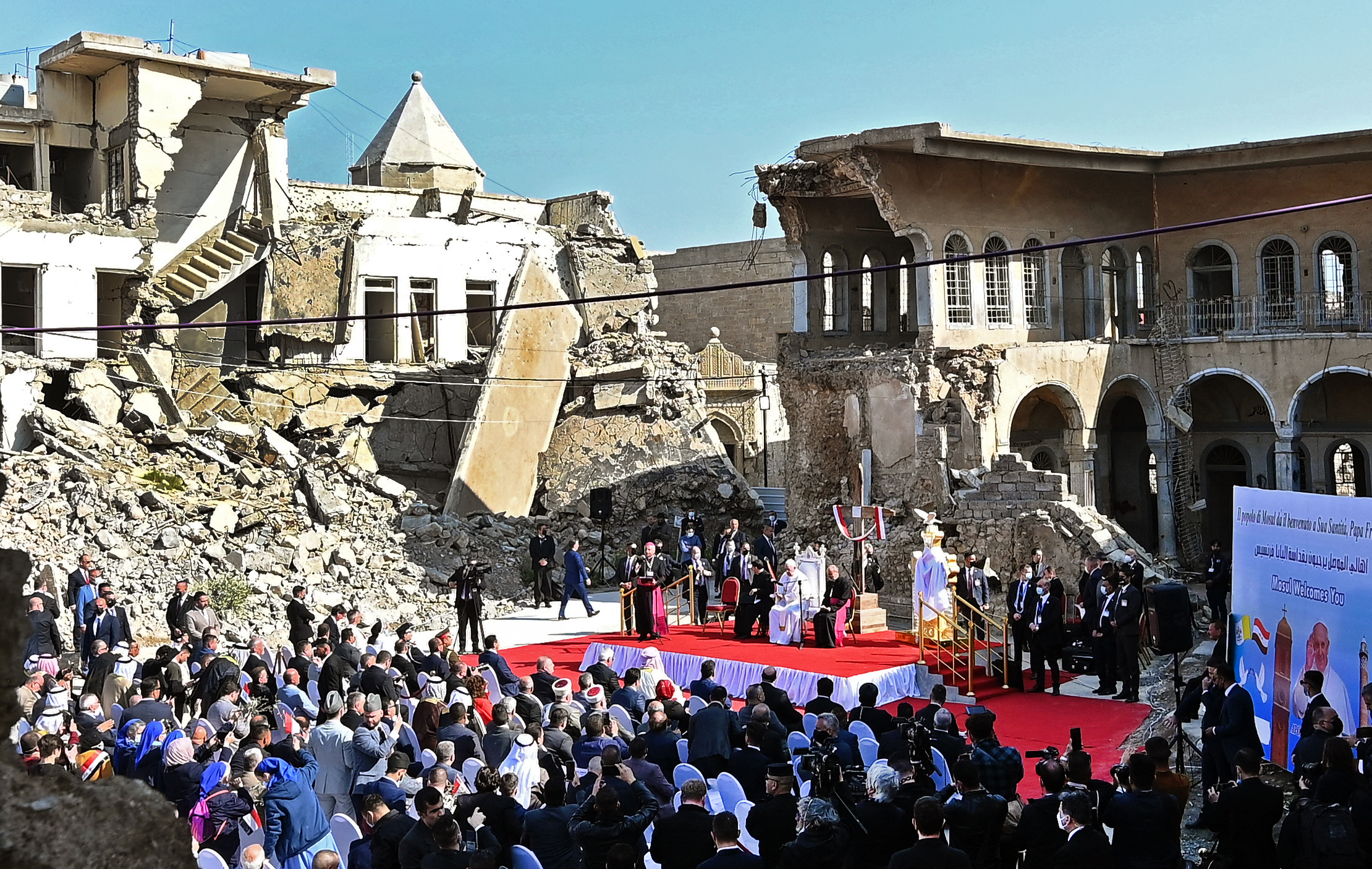 Pope Francis speaks at a square near the ruins of the Syriac Catholic Church of the Immaculate Conception (Al-Tahira-l-Kubra), in the old city of Iraq’s northern Mosul on March 7, 2021. Pope Francis, on his historic Iraq tour, visited Christian communities that endured the brutality of the Islamic State group until the jihadists’ “caliphate” was defeated three years ago