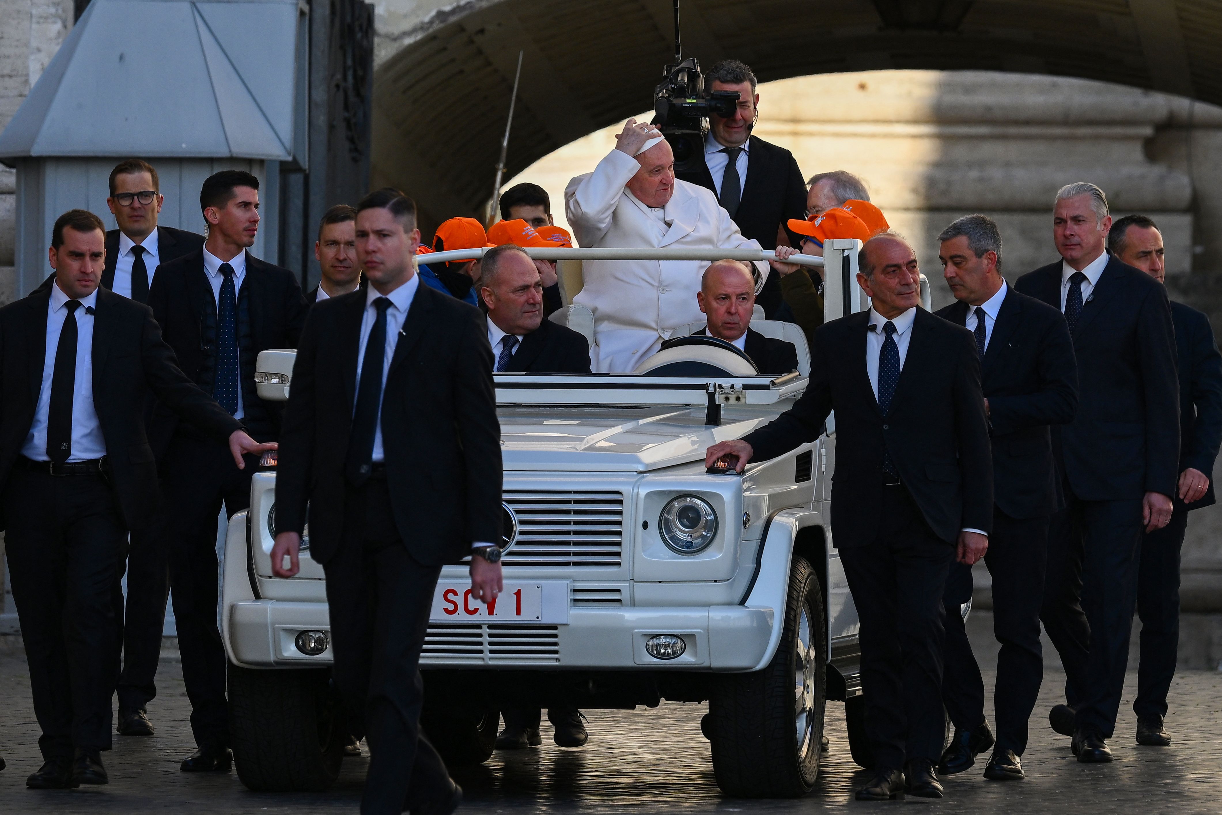 Bodyguards escort Pope Francis as he arrives in the popemobile car at St. Peter’s square on March 29, 2023 in the Vatican to hold the weekly general audience.