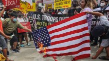 Demonstrators burn mock U.S. flag during rally in front of Camp Aguinaldo military headquarters in Quezon City, Philippines on Tuesday, April 11, 2023 as they protest against opening ceremonies for the joint military exercise flag called "Balikatan," Tagalog for shoulder-to-shoulder. The United States and the Philippines on Tuesday launch their largest combat exercises in decades that will involve live-fire drills, including a boat-sinking rocket assault in waters across the South China Sea and the Taiwan Strait that will likely inflame China. (AP Photo/Gerard Carreon)