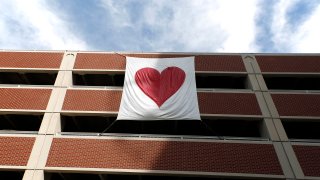 PORTLAND, ME – APRIL 20: The Valentine’s Bandit strikes again? Several hearts, including this banner tied to a parking garage, were hung around the emergency department entrance at Maine Medical Center, presumably in support for health care workers treating patients with COVID-19. (Staff photo by Ben McCanna/Portland Press Herald via Getty Images)