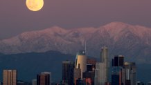 LOS ANGELES, CA. - DEC. 29 2020. A full moon rises over the snow-capped San Gabriel Mountains and the skyline of downtown Los Angeles on Tuesday, Dec. 29,2020. (Luis Sinco/Los Angeles Times via Getty Images)