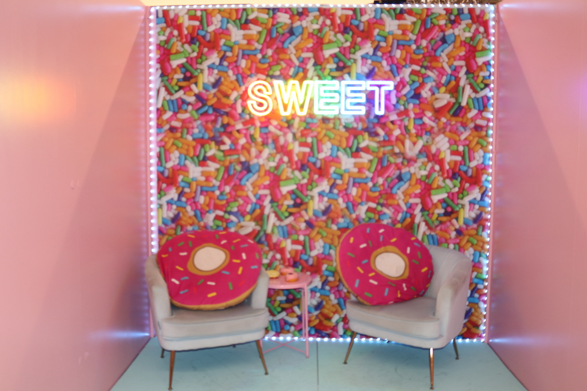 Donut pillows and a sweet "sprinkle" wall are some of the props available at Neon WRLD. | Photo credit: Whitney Ashton Irick