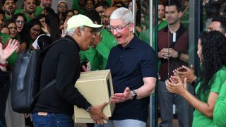 Tim Cook, Apple’s Chief Executive Officer (CEO) reacts as a man shows him Apple’s Macintosh outside the Apple store at Jio World Drive mall, Mumbai, India on April 18, 2023.