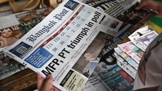 A man reads a Thai newspaper featuring front page coverage of Thailand’s general election at a newsstand in Bangkok on May 15, 2023. (Photo by Lillian SUWANRUMPHA / AFP) (Photo by LILLIAN SUWANRUMPHA/AFP via Getty Images)