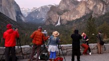 People paint and take photos as water flows forcefully down Bridalveil Fall in Yosemite Valley on April 27, 2023 in Yosemite National Park, California.