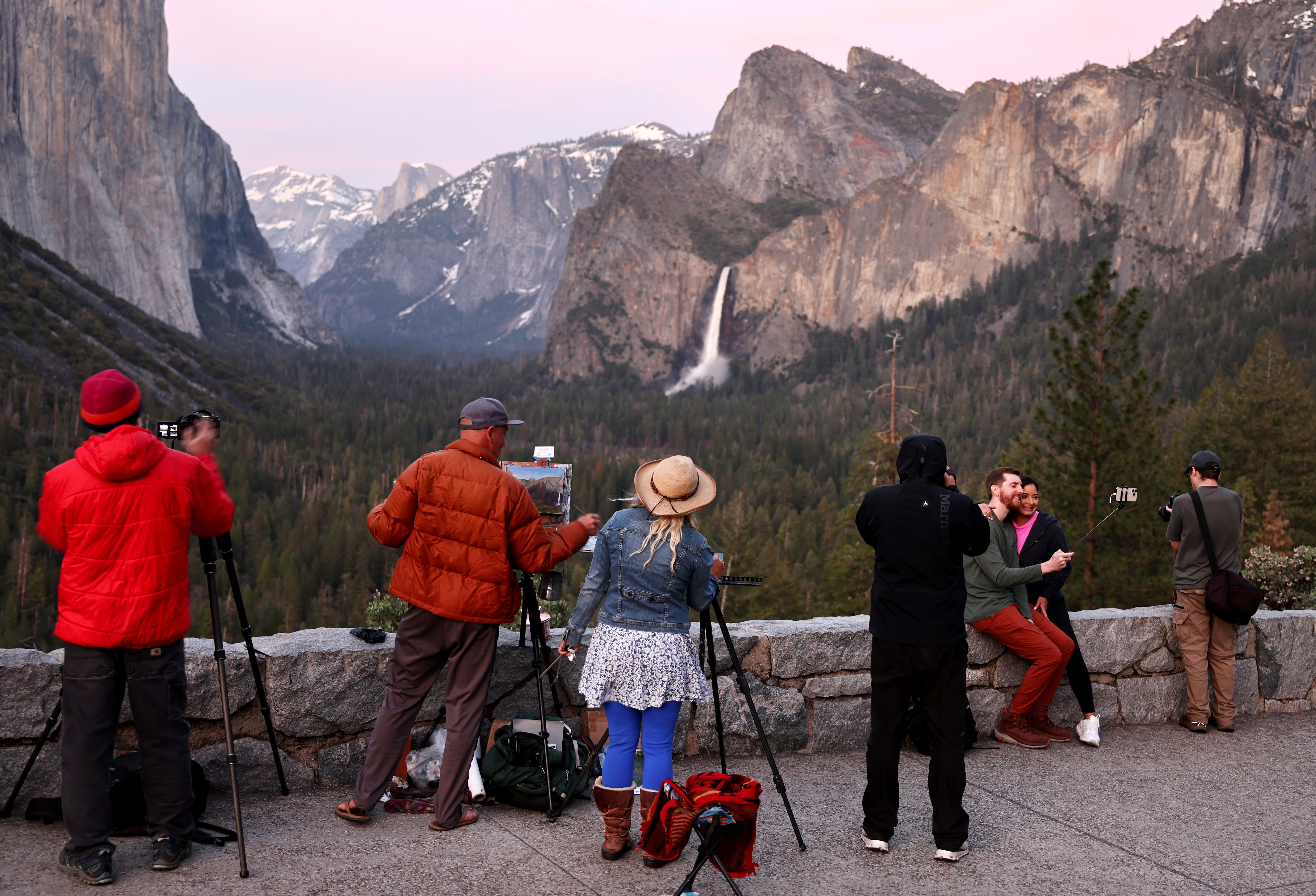 People paint and take photos as water flows forcefully down Bridalveil Fall in Yosemite Valley on April 27, 2023 in Yosemite National Park, California.