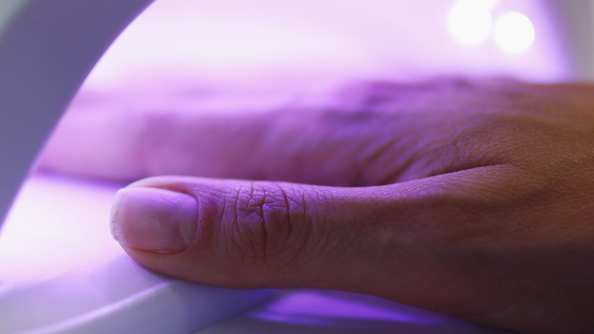 Close-up of woman putting hand under uv lamp.