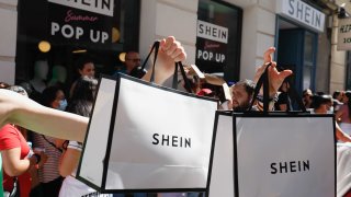 Two people hold two Shein bags after entering SHEIN’s first physical store in Madrid, Spain, June 2, 2022.