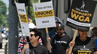 Hollywood writers and their supporters from the SAG AFTRA actors' union walk the picket line.