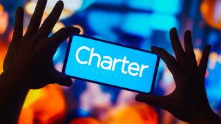 In this photo illustration, the Charter Communications logo is displayed on a smartphone screen.