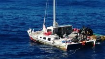 Tim Shaddock and his dog Bella being rescued by a fisherman boat after surviving months on a stranded catamaran.