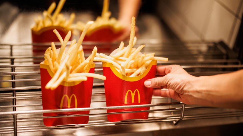 An employee places a bag of French fries in a grid at a branch of the McDonald's fast food chain.