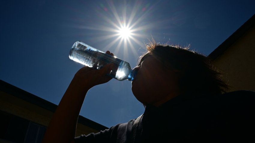 A child sips water from a bottle under a scorching sun on August 30, 2022 in Los Angeles, California. – Forecasters said the mercury could reach as high as 112 Fahrenheit (44 Celsius) in the densely populated Los Angeles suburbs in the next week as a heat dome settles in over parts of California, Nevada and Arizona. (Photo by Frederic J. BROWN / AFP) (Photo by FREDERIC J. BROWN/AFP via Getty Images)