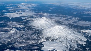 Aerial view northward of the central and northern Oregon Cascade Volcanoes, from South Sister in the right foreground to Mt. Jefferson to Mt. Hood. Mt. Adams can be faintly seen in the far background.