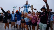 Fans hold a replica of the FIFA World Cup trophy and a cardboard cutout of Messi outside DRV PNK Stadium in Fort Lauderdale, Florida, on July 16, 2023, as Argentine soccer star Lionel Messi is presented as the newest player for Major League Soccer's Inter Miami CF. (Photo by Eva Marie UZCATEGUI / AFP) (Photo by EVA MARIE UZCATEGUI/AFP via Getty Images)