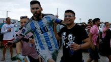 Fans carry a cardboard cutout outside DRV PNK Stadium in Fort Lauderdale, Florida, on July 16, 2023, as Argentine soccer star Lionel Messi is presented as the newest player for Major League Soccer's Inter Miami CF. (Photo by Eva Marie UZCATEGUI / AFP) (Photo by EVA MARIE UZCATEGUI/AFP via Getty Images)