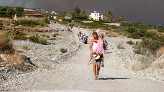 Tourists are evacuated as huge wildfire rages across Greece’s Rhodes island on July 22, 2023.