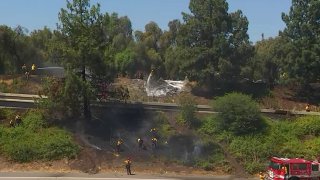 A small grass fire briefly threatened homes and closed the 118 Freeway Thursday northwest of Los Angeles.
