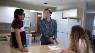Ryan Ratliff (C), Real Estate Sales Associate with Re/Max Advance Realty,  shows Ryan Paredes (L) and Ariadna Paredes a home for sale on April 20, 2023 in Cutler Bay, Florida. 