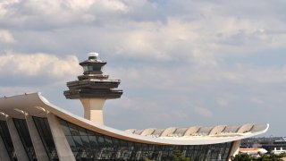 A good view of the Dulles airport terminal with the control tower in the background.