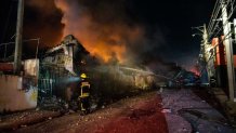 Firefighters work to extinguish a fire after an explosion in a commercial establishment in San Cristobal, Dominican Republic, on August 14, 2023. 