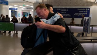 Michael White, a Navy veteran who was jailed in Iran for several years on spying charges, right, hugs former fellow prisoner and Iranian political activist Mahdi Vatankhah at the Los Angeles International Airport in Los Angeles, June 1, 2023.