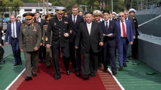 North Korea's leader Kim Jong Un, center right, Russian Defense Minister Sergei Shoigu, left, and Admiral Nikolai Yevmenov, Commander-in-Chief of the Russian Navy, center left, visit the Admiral Shaposhnikov frigate of the Russian navy in the port of Vladivostok, Russian Far East.