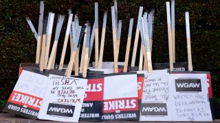 FILE - Placards are gathered together at the close of a picket by members of The Writers Guild of America outside Walt Disney Studios, Tuesday, May 2, 2023, in Burbank, Calif. On Sunday, Sept. 24, 2023, a tentative deal was reached to end Hollywood’s writers strike after nearly five months. (AP Photo/Chris Pizzello, File)