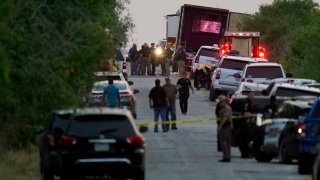 FILE – Police and other first responders work the scene after a tractor-trailer containing suspected migrants was found on June 27, 2022, in San Antonio.