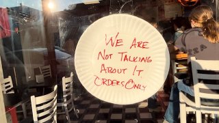 A sign reading, "We are not talking about it, orders only," at Dragon Pizza in Somerville, Massachusetts, on Friday, Sept. 1, 2023.