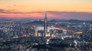 This photo taken on May 19, 2018 shows a general view of the Lotte tower (front C) and Namsan tower (rear C) amid the Seoul city skyline and Han river during sunset. (Photo by Ed JONES / AFP)