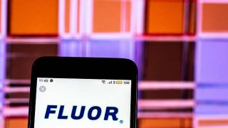 The Fluor Corporation logo is displayed on a smartphone.