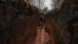 A Ukrainian infantryman walks along a trench in the mud after the rain on Nov. 9, 2023, in an area the military calls the “Horlivka front,” an urban-type settlement in Toretsk urban hromada, Donetsk Oblast, eastern Ukraine.