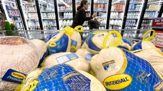 A shopper walks past turkeys displayed for sale in a grocery store ahead of the Thanksgiving holiday on November 11, 2021 in Los Angeles, California.