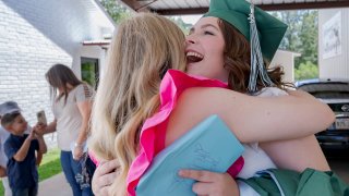 Khyli Barbee, 15, wearing mortar cap, is hugged by her mother.