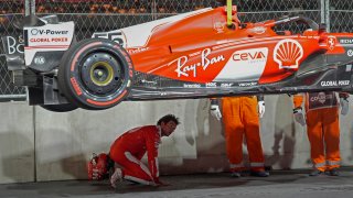 Ferrari driver Carlos Sainz, of Spain, looks at the bottom of his car after running over a manhole cover during the first practice session for the Formula One Las Vegas Grand Prix auto race, Thursday, Nov. 16, 2023, in Las Vegas. (AP Photo/Nick Didlick)