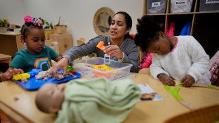 Teacher works with children during a preschool class