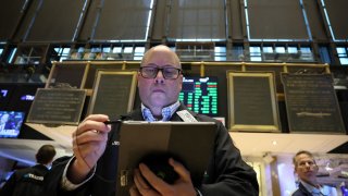 Traders work on the floor at the New York Stock Exchange (NYSE) in New York City, U.S., January 23, 2024. 